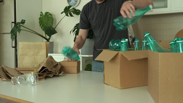 Caucasian man is separating trash and sort waste in garbage box for recycling at home. Recycle box. Saving the natural environment. Eco friendly concept. Trash sorting. Close up. 4k footage