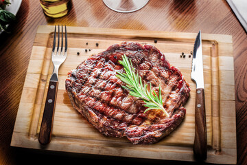 Grilled medium rare steak Mignon on wooden board ready to be eaten.