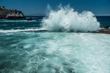Obraz premium Rocky coastline and big wave breaking on natural swimming pool of Tenerife Island.