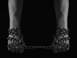 Mans hand entangled with a metal chain, concept slavery, hostage and freedom.Black and white photo.