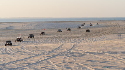 Fototapeta na wymiar People driving quad bikes on the dunes in sealine.