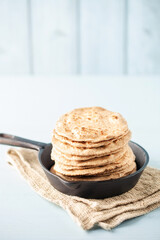Homemade Indian Traditional Flatbread called Chapati on a white wooden background. Baked indian flatbread. Indian