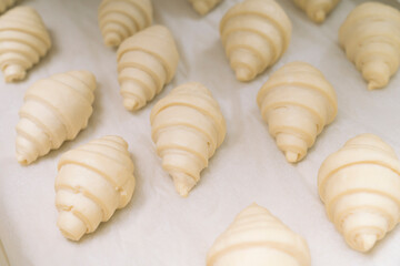 Fototapeta na wymiar Food background. Fresh homemade croissants. Close up shot of Uncooked traditional french pastry. Ready to cook croissant.