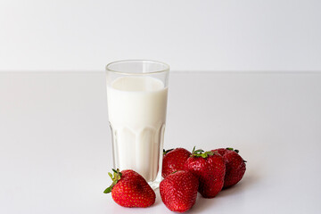 A glass of fresh milk and fresh ripe strawberries. Fresh organic yogurt with strawberries on white...