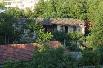 Plakat Stone house between the trees in breathtaking nature. The old architecture in the greenery. 