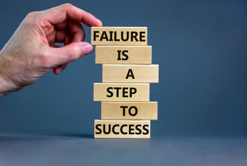 Failure or success symbol. Wooden blocks with words A failure is a step to success. Beautiful grey table grey background. Businessman hand. Business, failure or success concept. Copy space.