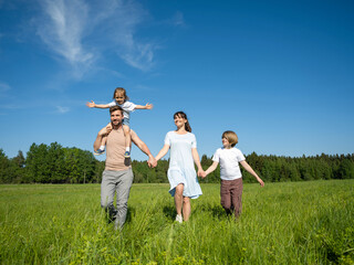 Happy family walking on meadow