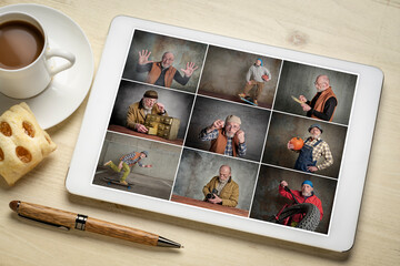 reviewing a set of studio portraits on a digital tablet featuring the same senior male model with a variety of props and added background texture