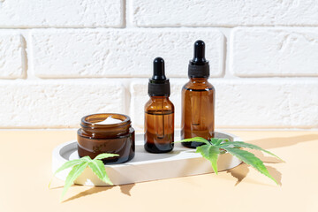 Hemp cbd oil serum in glass dropper bottle with cannabis leaves, Moisturizing cream, Serum, lotion, essential oil. Cannabis leaves with skincare cosmetic product. Natural eco cosmetics