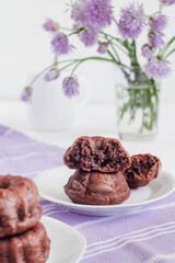 Broken fresh chocolate muffin on a table with lilac napkin. Muffin dough texture.