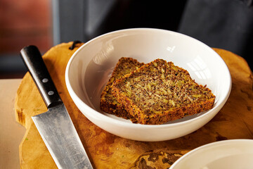 Whole grain bread slices on plate and kitchen knife on table