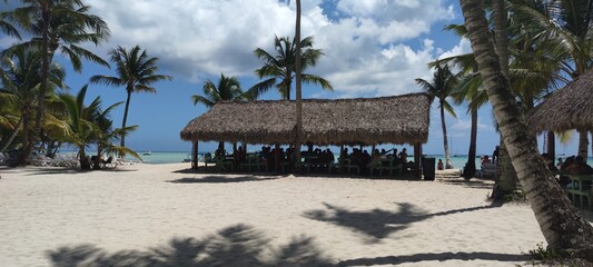 Large gazebo bay on a clean white sand beach. Green palm trees all around. Wonderful scenery in the...