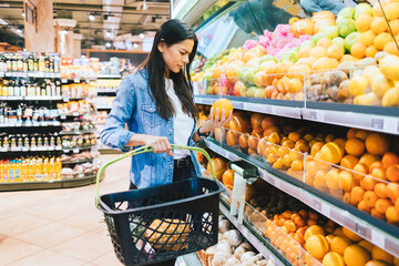Picky shopper young woman chooses oranges fruits