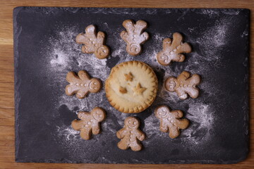Obraz na płótnie Canvas Mince Pie with Gingerbread Men on Slate