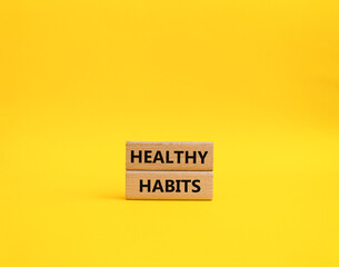Healthy habits symbol. Concept word Healthy habits on wooden blocks. Beautiful yellow background....