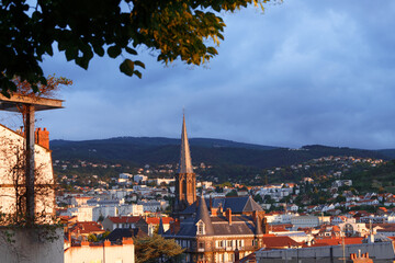 Fototapeta premium Morning aerial cityscape view on Clermont-Ferrand city with mountains on the background in central France