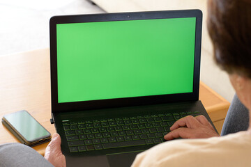 Green screen laptop computer closeup. Unknown senior lady having video call at chroma key laptop...