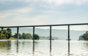 high bridge under Dnister river and people on sport catamarans, National Nature Park Dnister Canyon, Ukraine