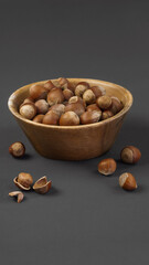 hazelnuts on a dark matte gray background close-up in a wooden plate, close-up