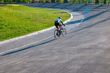 Obraz premium Cyclist training on the cycle-racing track in the park. Biker or bicycle sport