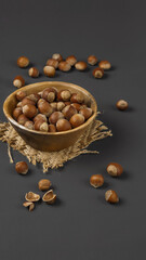 hazelnuts on a dark matte gray background close-up in a wooden plate, close-up