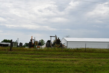 Fototapeta premium Tractors and a Barn in a Farm field