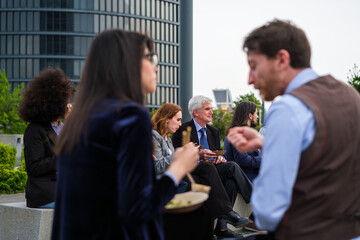 Group of business district workers taking a break - focus on white-haired man