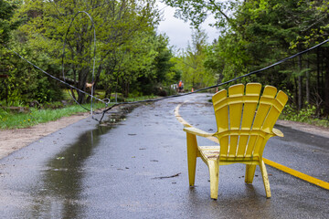 Plastic garden chair is seen blocking a highway with fallen overhead electricity cable causing...