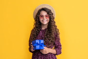 glad girl with curly hair hold present box on yellow background