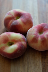 Plattpfirsiche auf einem Holzbrett