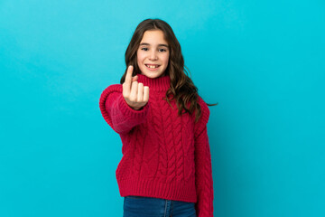 Fototapeta premium Little caucasian girl isolated on blue background doing coming gesture