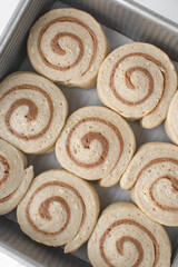 Proofed cinnamon roll dough in a metal tin, dough that has doubled in size, pastry dough that has risen