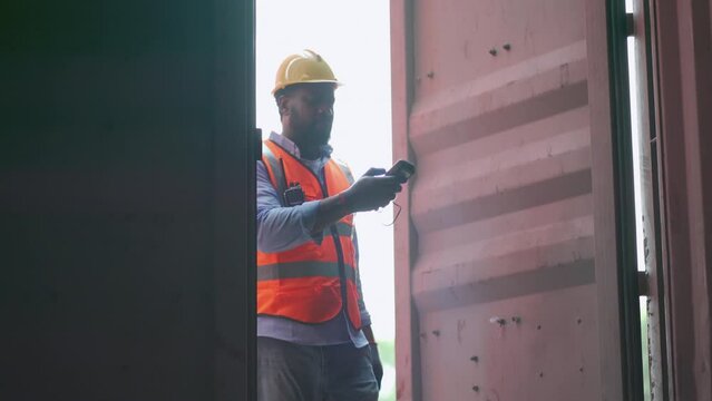 African American cargo container worker open door of the tank and check product inside using barcode scaner then close the door after finish work.