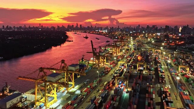Shipping port, cargo container ship, crane, and car traffic transport in Asia city at sunset. Logistic industry or freight transportation business concept, drone aerial view