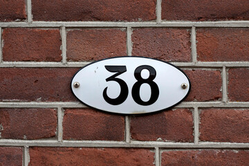House number 38 sign on a brick wall
