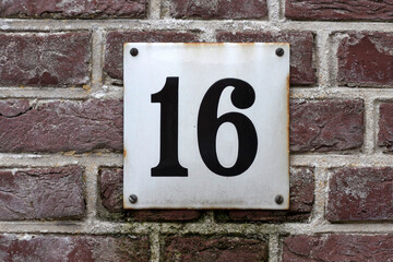 House number  16 sign on a brick wall