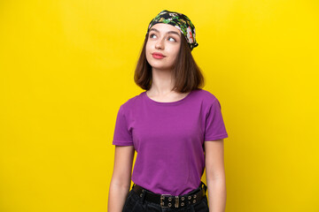 Young Ukrainian woman isolated on yellow background thinking an idea while looking up