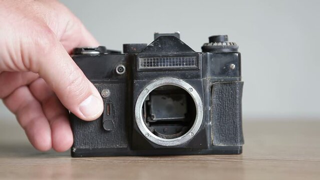 An old SLR camera without a lens. Retro photo camera lies on the table. Rare camera.