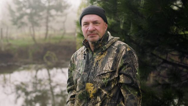 The hunter look around at the lake and in a moment sees the prey near the autumn misty lake