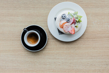 Pavlova dessert and a cup of coffee on the table