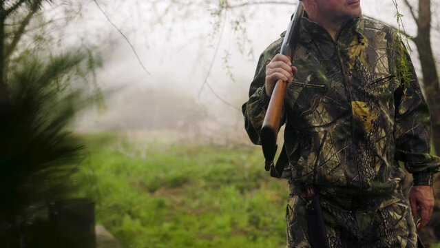 Hunter walks with dog on a hunt on a foggy lawn