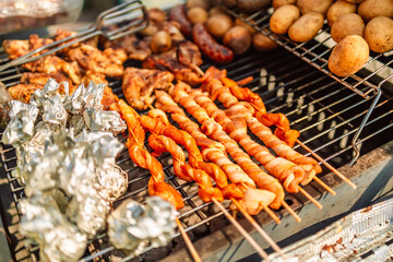 Grilled tasty sausage with the addition of herbs and vegetables on the grill plate. Grilling food, bbq, barbecue
