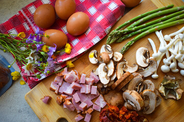 Mushrooms, asparagus and bacon cut on a wooden board.