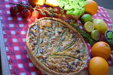 Quiche Lorraine Tart. Egg and cheese tart on pastry crust filled with savoury custard and pieces of cheese, bacon, and asparagus.