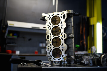 Damaged car engine near tools in garage 