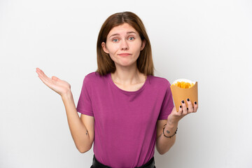 Young English woman holding fried chips isolated on white background having doubts while raising hands