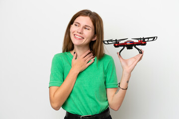 Young English woman holding a drone isolated on white background looking up while smiling