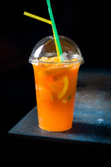 Orange lemonade with orange slices on dark style on dark blue table