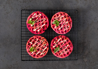 Obraz na płótnie Canvas Small Round beetroot waffles, on a serving stand. Dark gray background. Top view