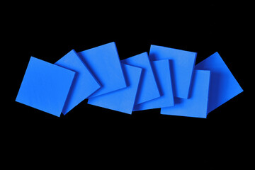 Abstract shaped blue square solid pieces on black background.